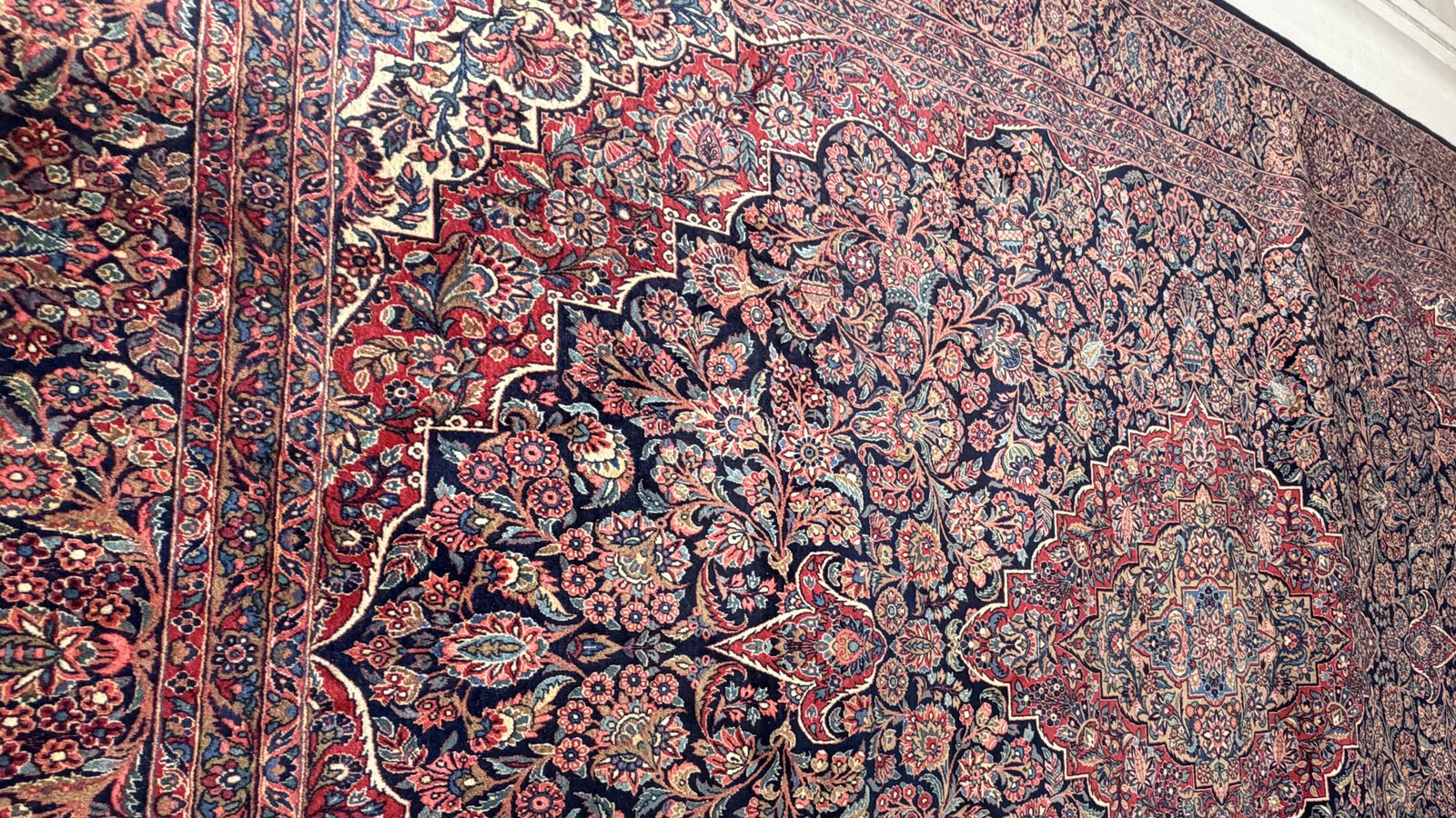 A rug laid flat and checked over before it is rolled onto a tube for storage
