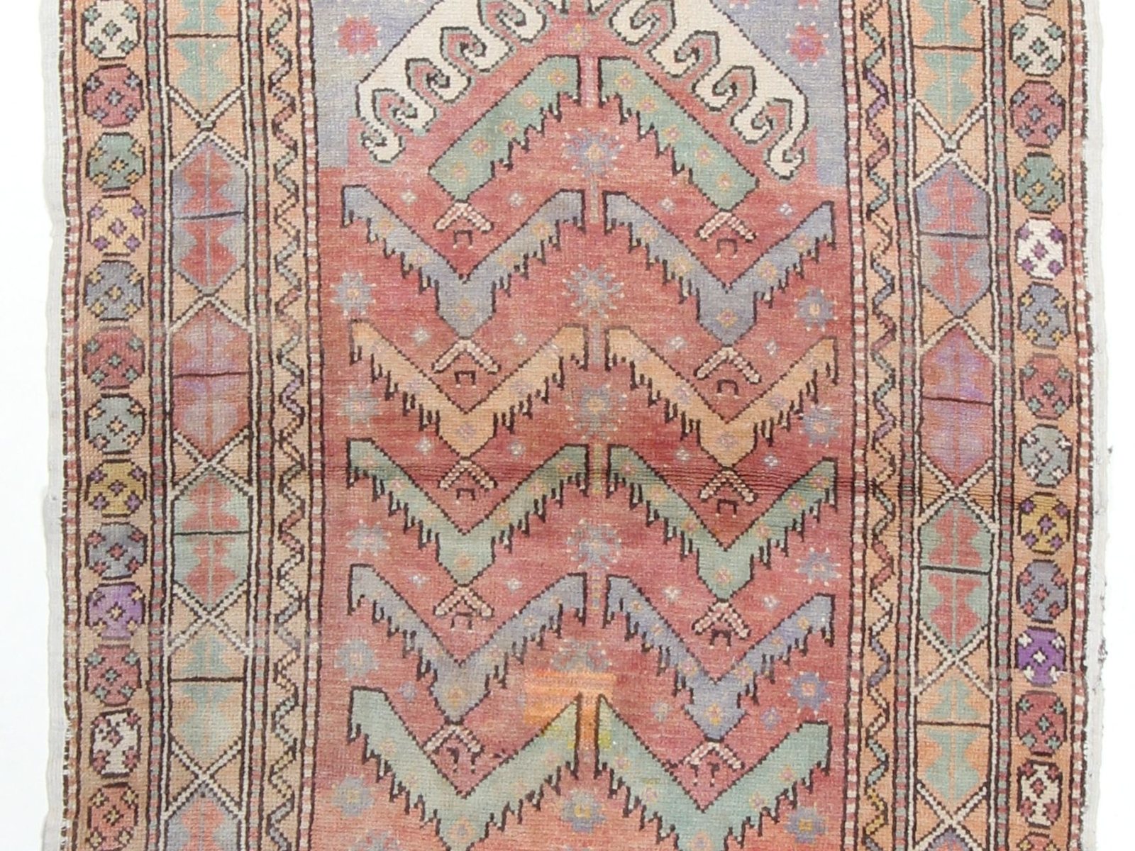Turkish rug detail showing a geometric medallion and a wide bordered field